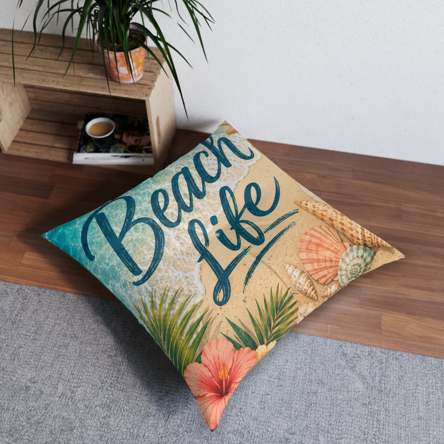 Square tufted floor pillow with 'Beach Life' beach design and seashells in beige and teal.
