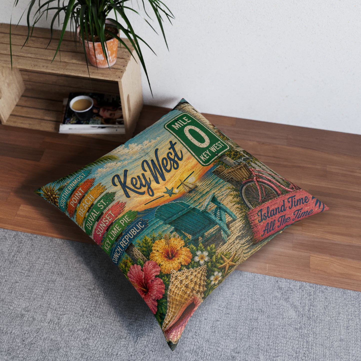 Square tufted floor pillow with Key West city signage and tropical floral print in teal and orange.