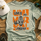 T-shirt with 'Love is My Mother Language' design on a wooden surface with accessories.