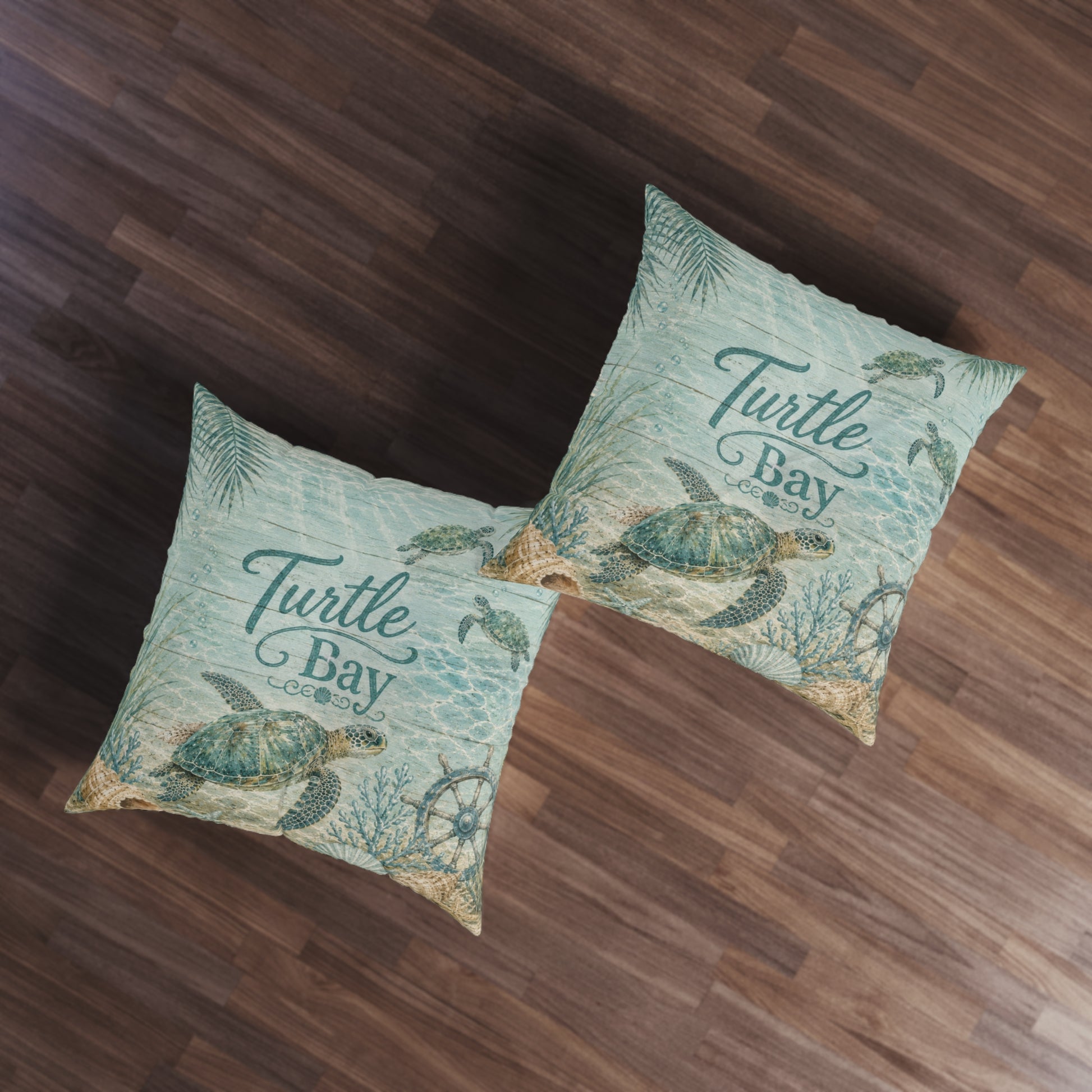 Two square turquoise floor pillows with sea turtle prints and “Turtle Bay” lettering