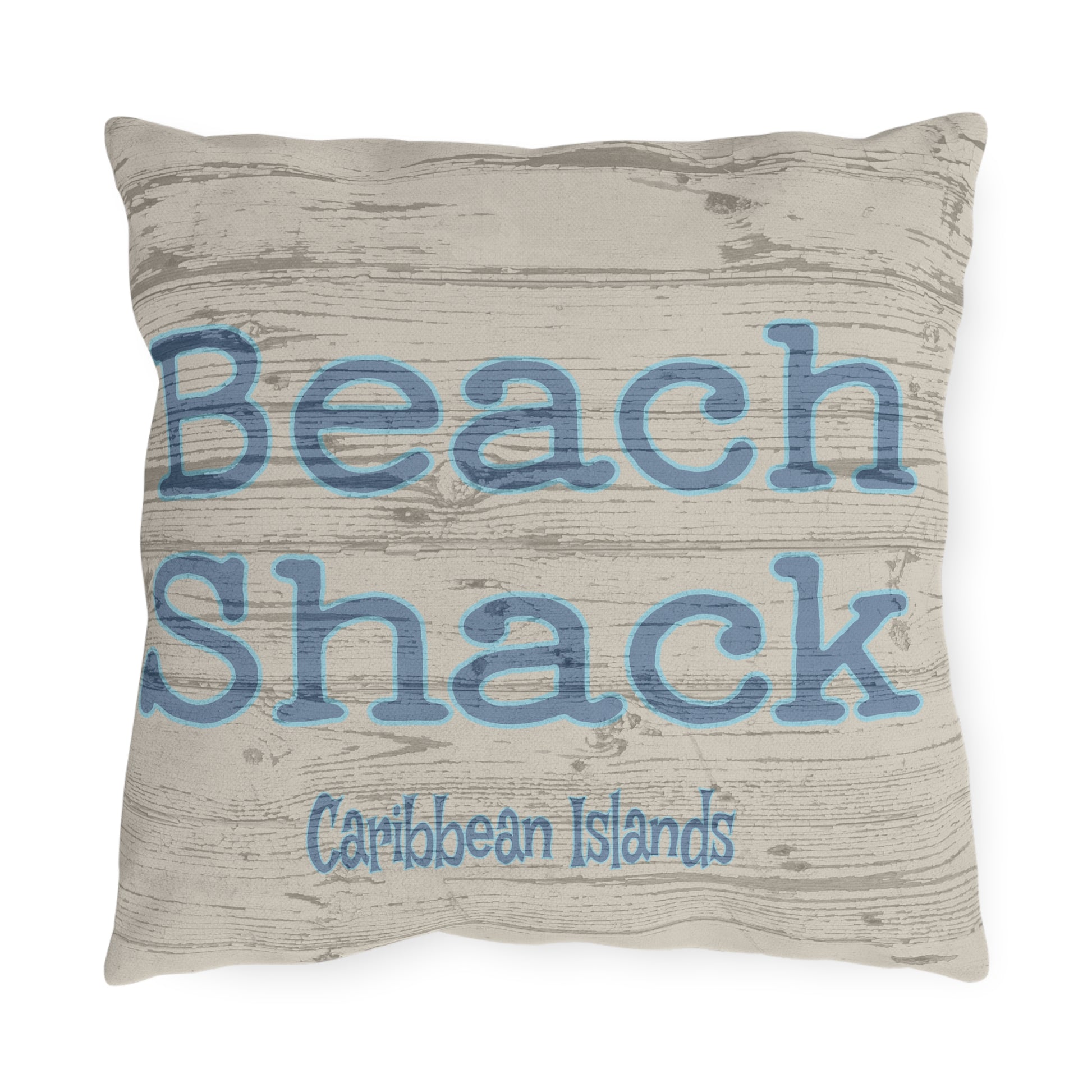 Pillow with 'Beach Shack Caribbean Islands' text on a wooden texture background
