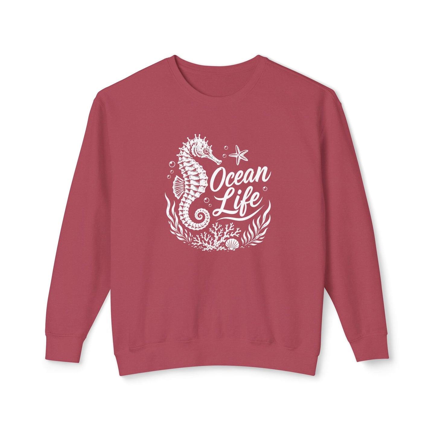 A dusty rose crewneck sweatshirt featuring a white graphic print of a seahorse, starfish, coral, and the text 'Ocean Life' on the front, displayed against a solid white background.
