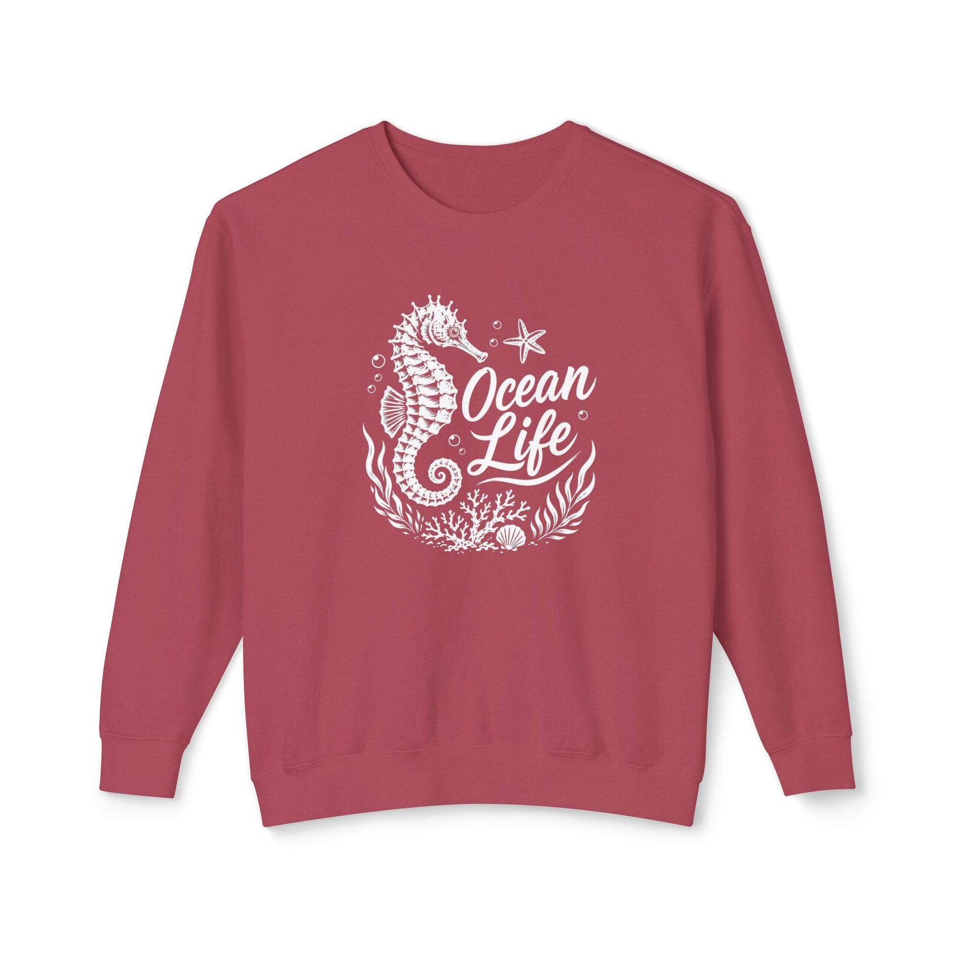 A dusty rose crewneck sweatshirt featuring a white graphic print of a seahorse, starfish, coral, and the text 'Ocean Life' on the front, displayed against a solid white background.
