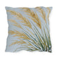 Decorative pillow with gold and green leaf pattern on a light blue background