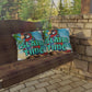 Decorative pillows with parrot design and 'Island Time' text on a swing against a stone wall and greenery background.