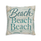 Square floor pillow, close-up, teal “Beach” text on light fabric with seashell corner details