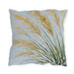 Decorative pillow with gold and green leaf pattern on a light blue background