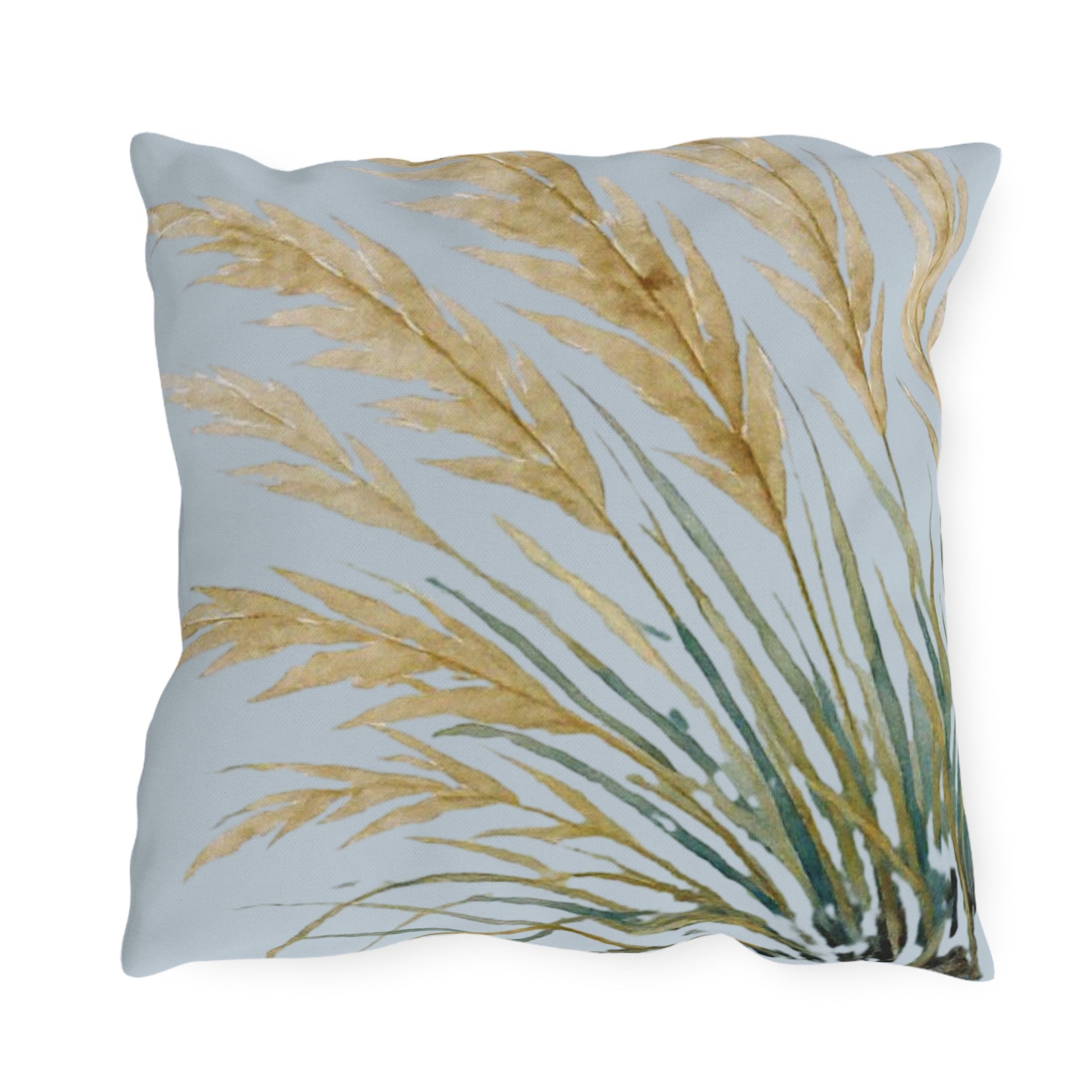Decorative pillow with gold and green leaf pattern on a light blue background