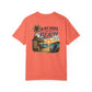Coral t-shirt with beach graphic and text on a white background