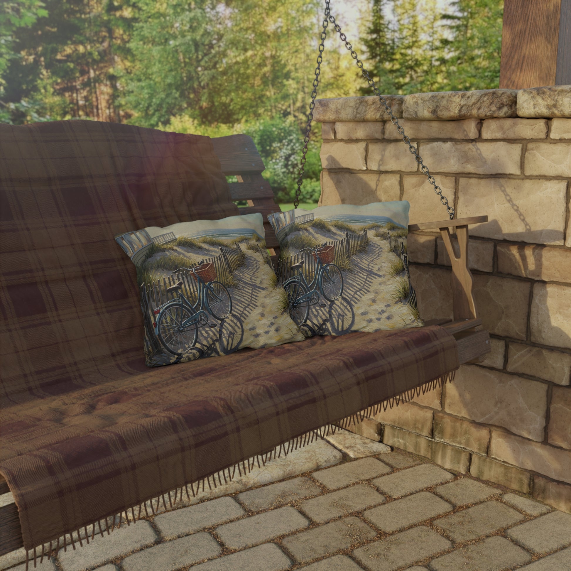 Wooden swing with plaid cover and decorative pillows on a stone patio