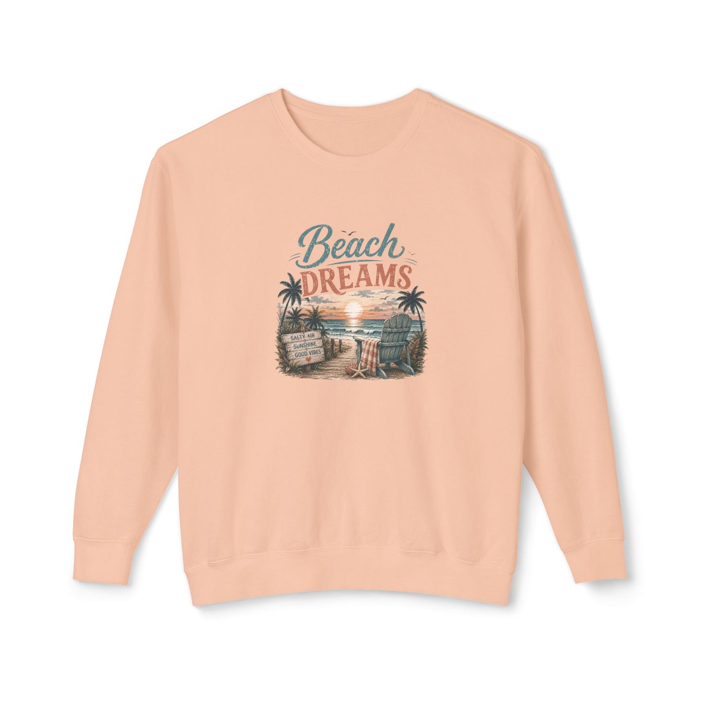 A peach-colored crewneck sweatshirt featuring a retro-style graphic on the chest that reads 'Beach DREAMS' above a beach scene with palm trees, a sunset, and a boardwalk sign.