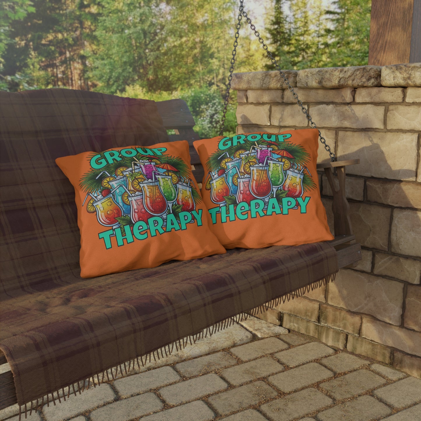 Two pillows with 'Group Therapy' design on a swing outdoors.