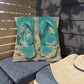 Pillow with teal flip-flop design on a wooden bench