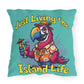 Pillow with a parrot design holding a cocktail and text 'Just Living the Island Life' on a teal background.