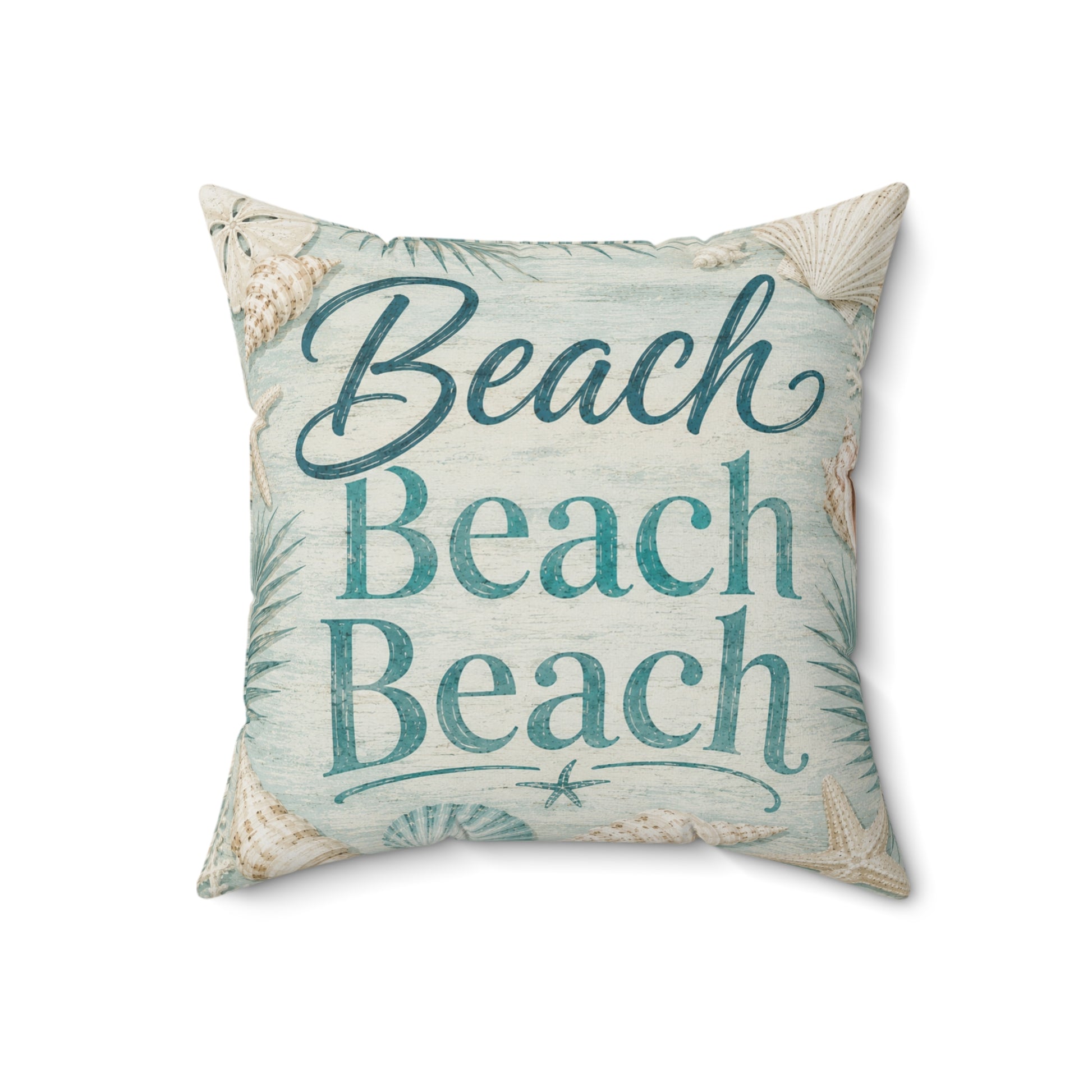 A square decorative throw pillow featuring the phrase 'Beach Beach Beach' in teal script and block lettering, surrounded by a seashell and palm leaf pattern on a light blue and beige background.