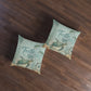 Two square decorative throw pillows with a vintage-style 'Turtle Bay' nautical print, displayed on a dark wood floor.