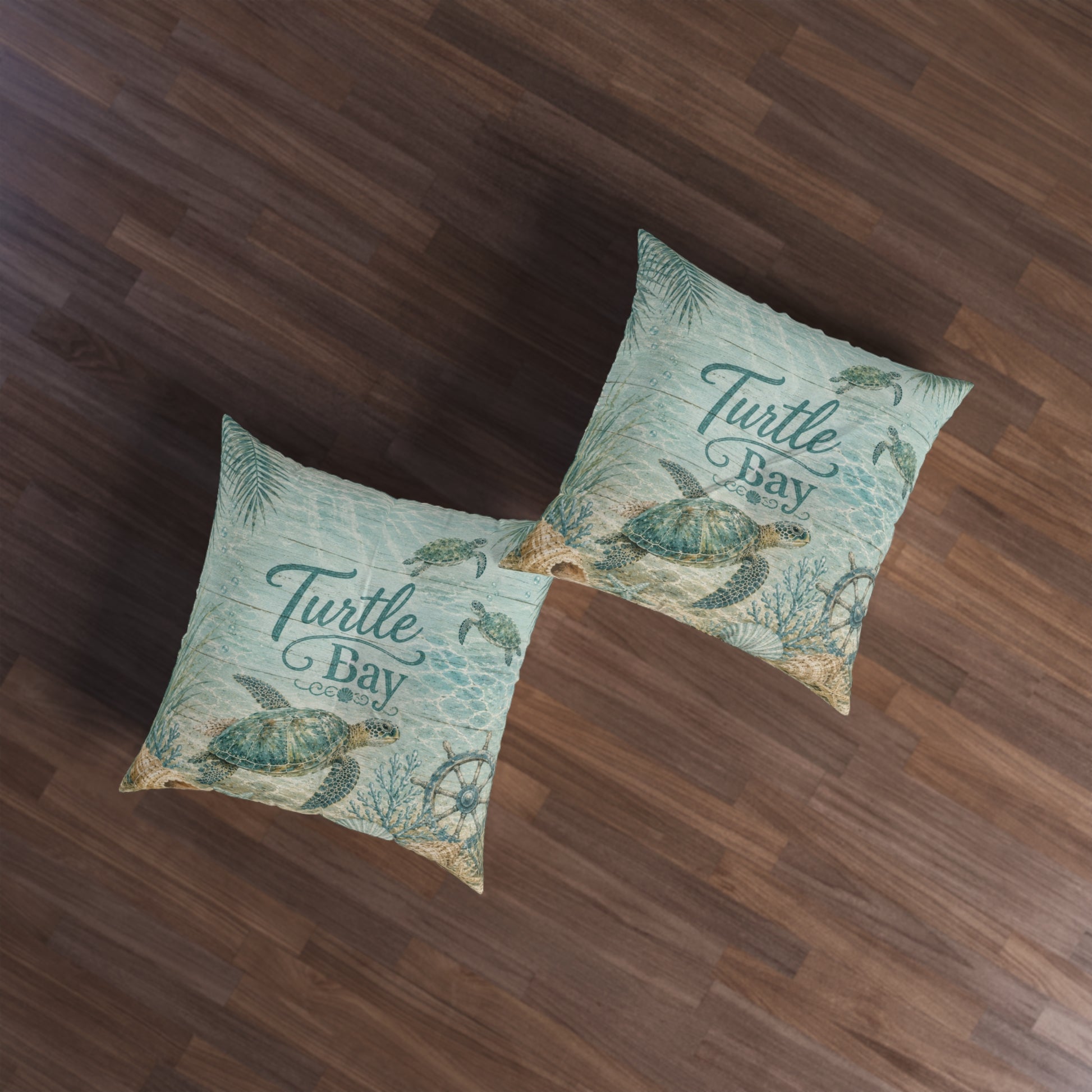 Two square decorative throw pillows with a vintage-style 'Turtle Bay' nautical print, displayed on a dark wood floor.