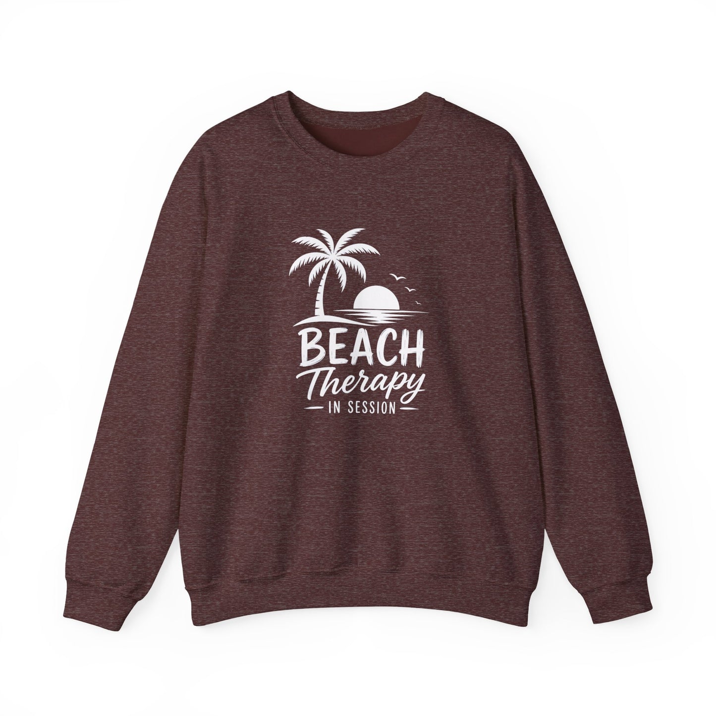 A heathered dark brown crewneck sweatshirt featuring a white graphic print of a palm tree, sunset, and the text 'BEACH Therapy IN SESSION' on the front, displayed against a solid white background.