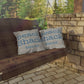 Wooden swing with 'Beach Shack' pillows against a stone wall and greenery.