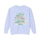 Light blue sweatshirt with 'Born to be a Beach Girl' text and beach-themed graphics on a white background at Caribbean Rays