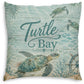Square decorative throw pillow featuring a sea turtle ocean scene with the words 'Turtle Bay' in teal script over a light aqua watercolor-style background with palm leaves, coral, and a ship wheel.
