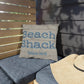 Pillow with 'Beach Shack Caribbean Islands' text on a wooden bench