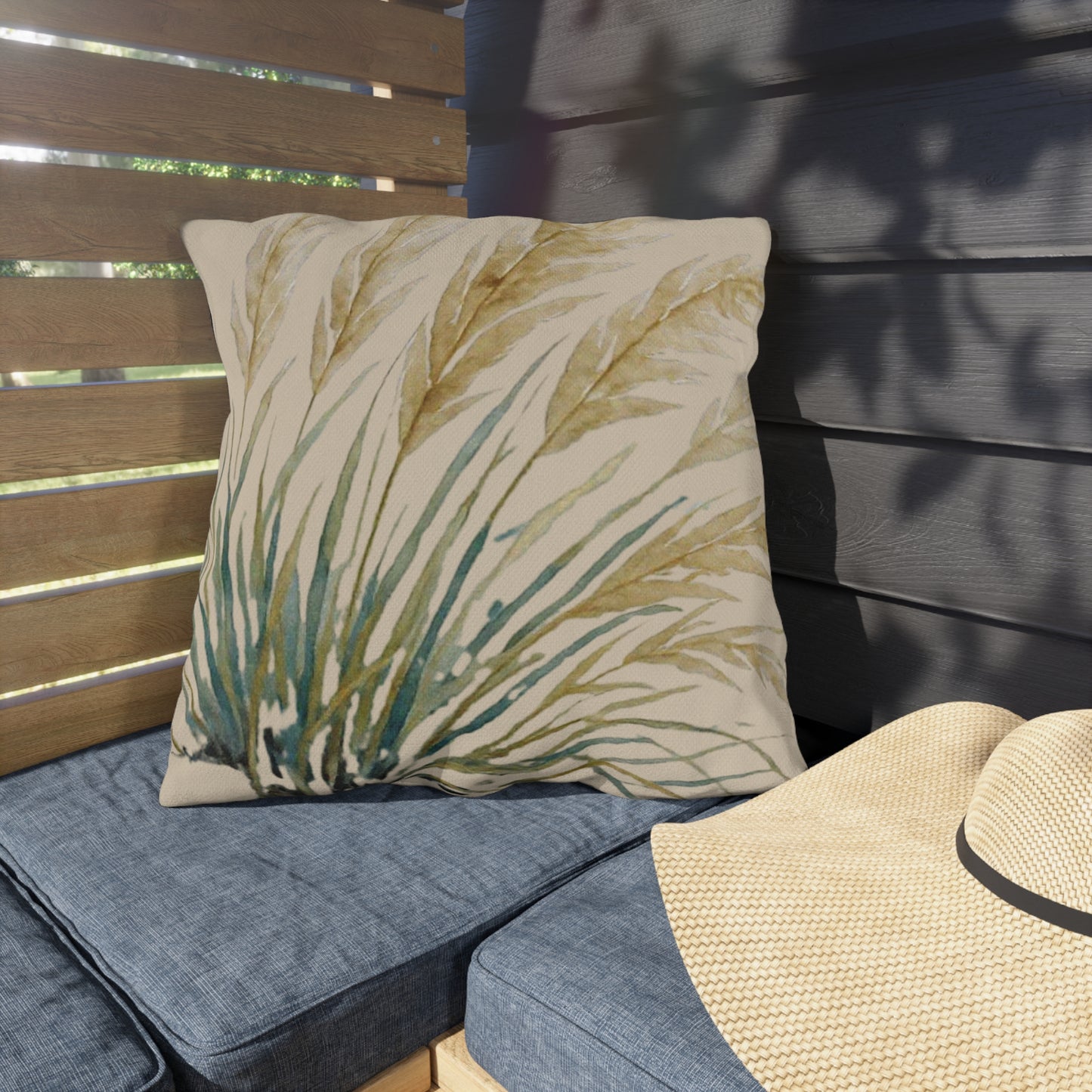 Decorative pillow with leaf pattern on a cushioned outdoor bench