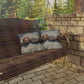 Wooden swing with plaid blanket and decorative pillows on a stone patio