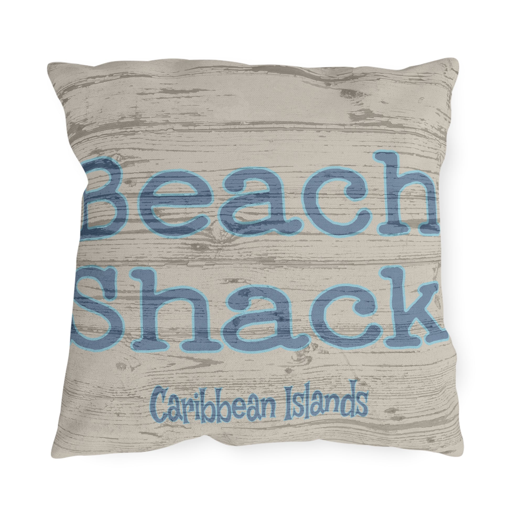 Pillow with 'Beach Shack Caribbean Islands' text on a wooden texture background