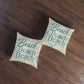 Square floor pillow with teal “Beach Beach” print and seashell accents, pair on wood floor