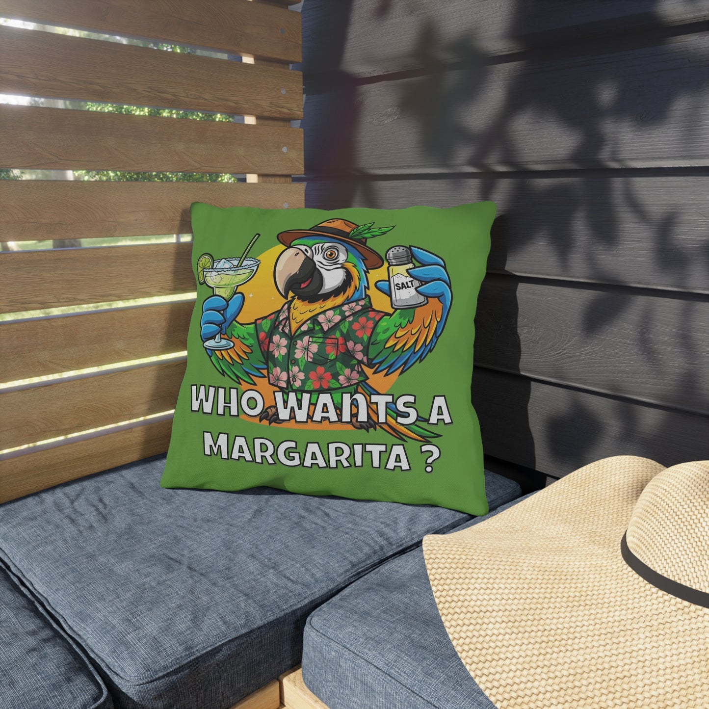 Colorful parrot pillow with 'Who Wants a Margarita?' text on a patio setting.