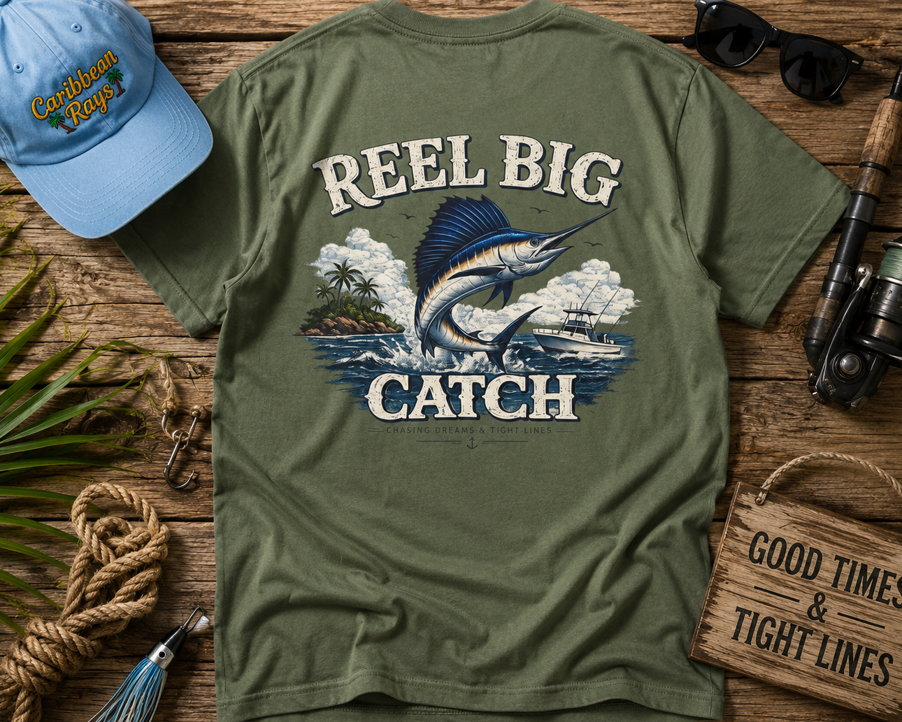 Green t-shirt with 'Reel Big Catch' design on a wooden surface with fishing-themed accessories.