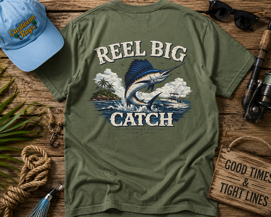 Green t-shirt with 'Reel Big Catch' design on a wooden surface with fishing-themed accessories.