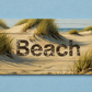 Wooden sign with 'Beach' text on a sandy background with grass, on a blue background
