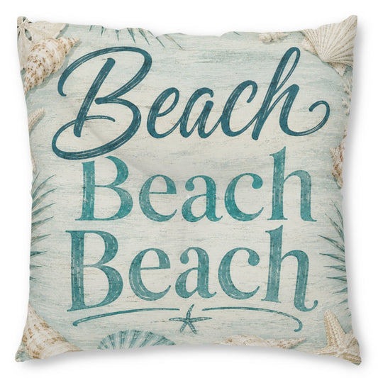 A square decorative throw pillow featuring the phrase 'Beach Beach Beach' in teal script and block lettering on a distressed light blue and off-white background, decorated with seashell and palm leaf illustrations.