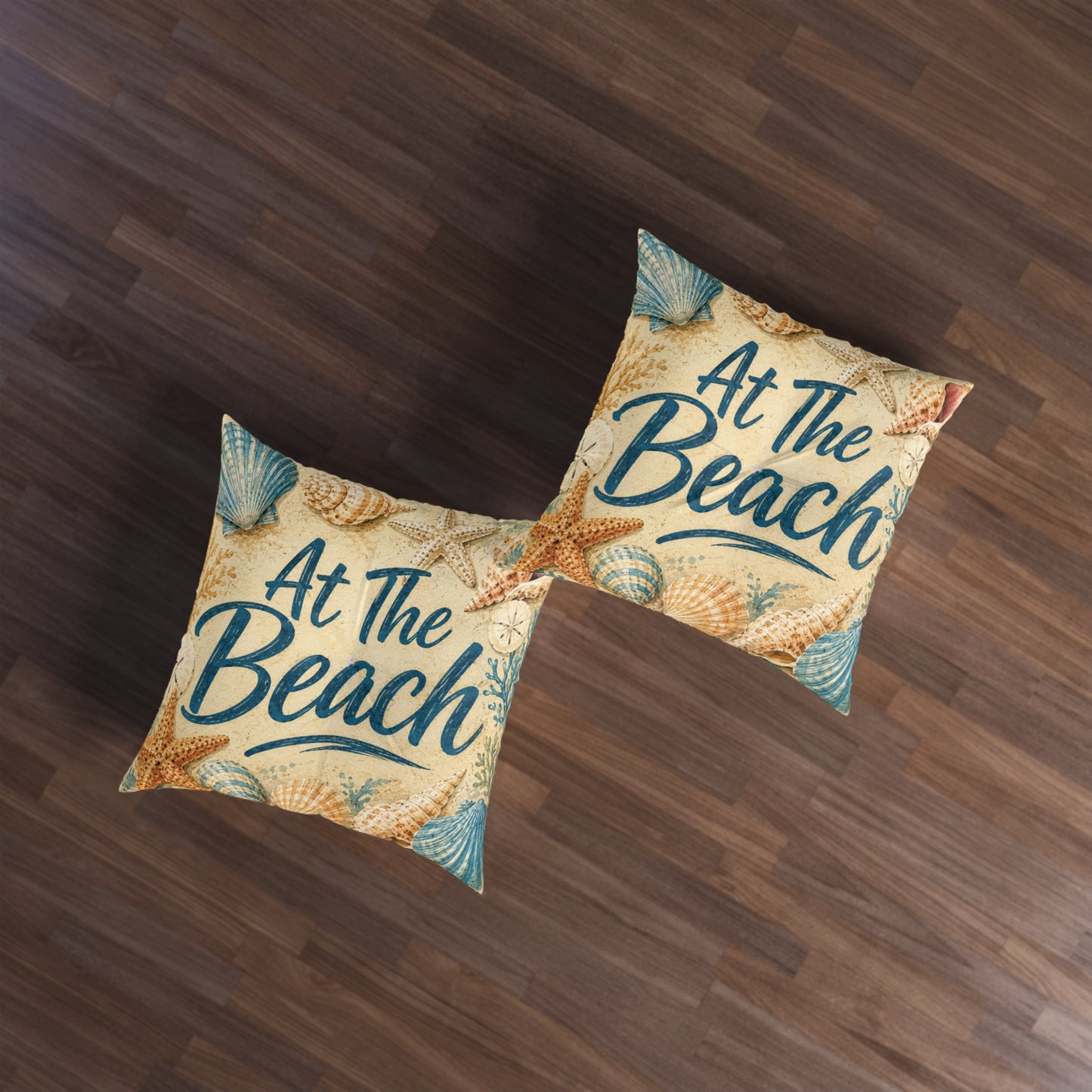 Square tufted floor pillows, beige beach theme with seashells and teal 'At The Beach' text