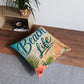 Square tufted floor pillow with 'Beach Life' seashell and palm print in beige and teal.