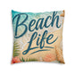 Square tufted floor pillow with 'Beach Life' script, seashell and sand print in beige and teal.