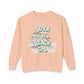 Peach sweatshirt with 'Born to be a Beach Girl' text and beach-themed graphics on a white background at Caribbean Rays
