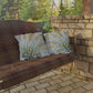 Wooden swing with patterned cushions against a stone wall and greenery background