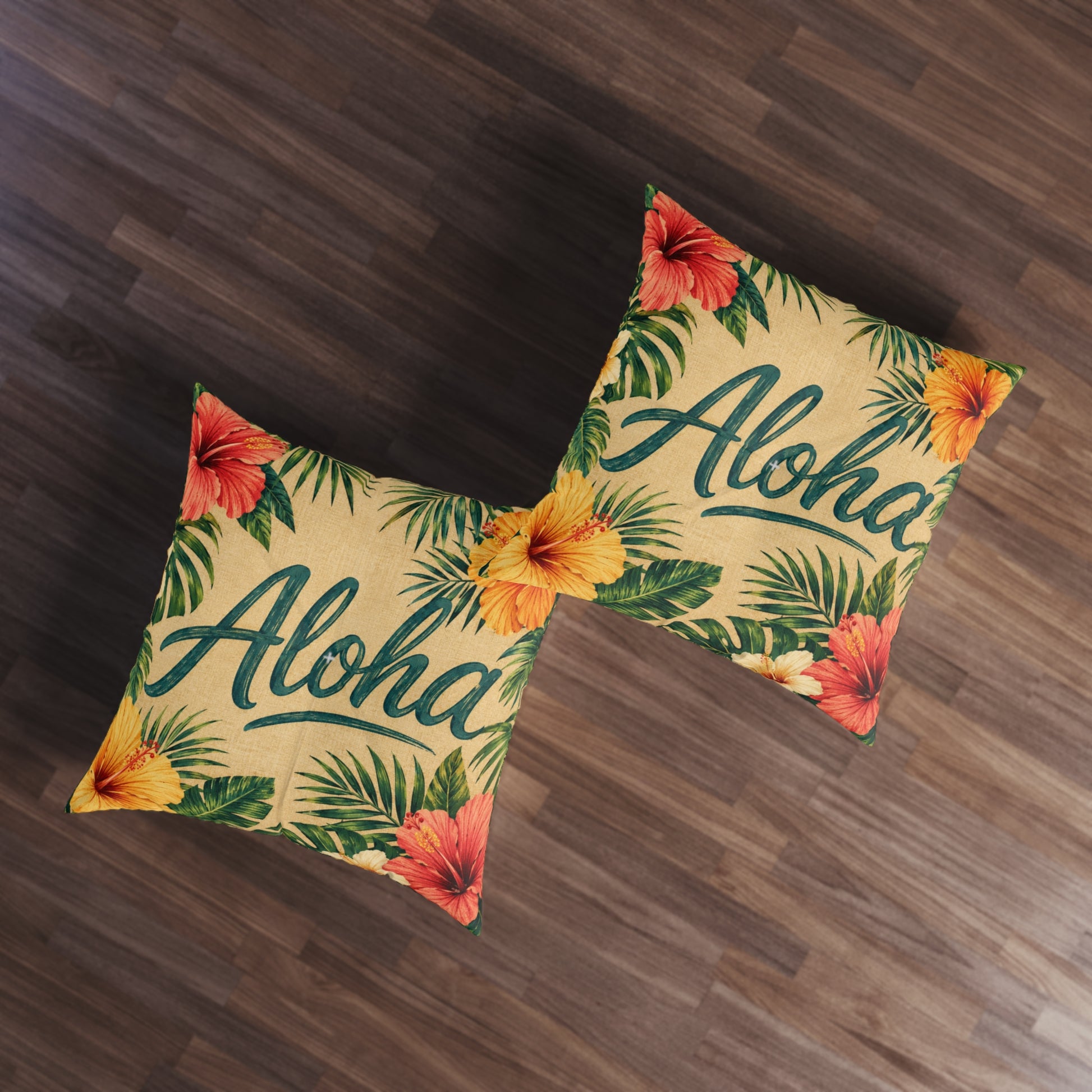 Square tufted floor pillows with Aloha lettering, hibiscus blooms, and palm leaf print on tan