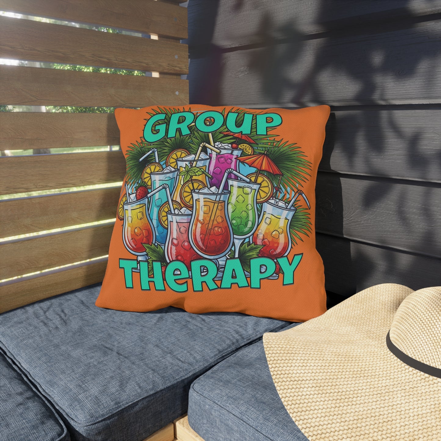 Colorful pillow with 'Group Therapy' text and drink graphics on a wooden bench.