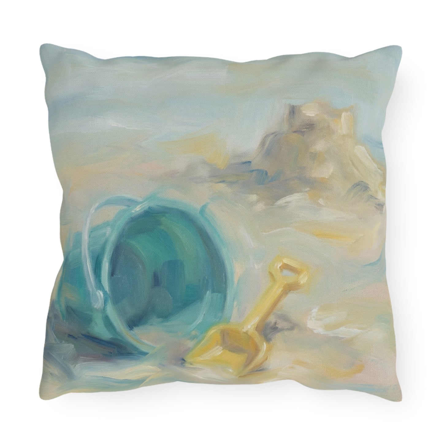 Decorative pillow with a beach theme featuring a blue bucket and yellow shovel on a white background.