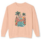 A peach-colored crewneck sweatshirt featuring a colorful graphic on the front with the text 'I'm Always a Beach Girl' in stylized lettering, accompanied by palm trees, hibiscus flowers, and ocean waves.