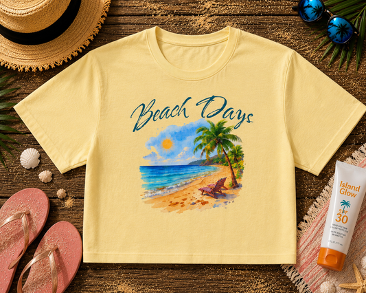 Yellow t-shirt with 'Beach Days' design on a wooden surface with beach accessories.