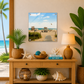 Decorative setup with a beach scene print, plants, and a lamp on a wooden console table.