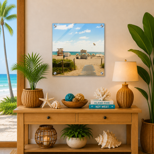 Decorative setup with a beach scene print, plants, and a lamp on a wooden console table.