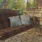 Wooden swing with plaid cover and patterned cushions on a stone patio