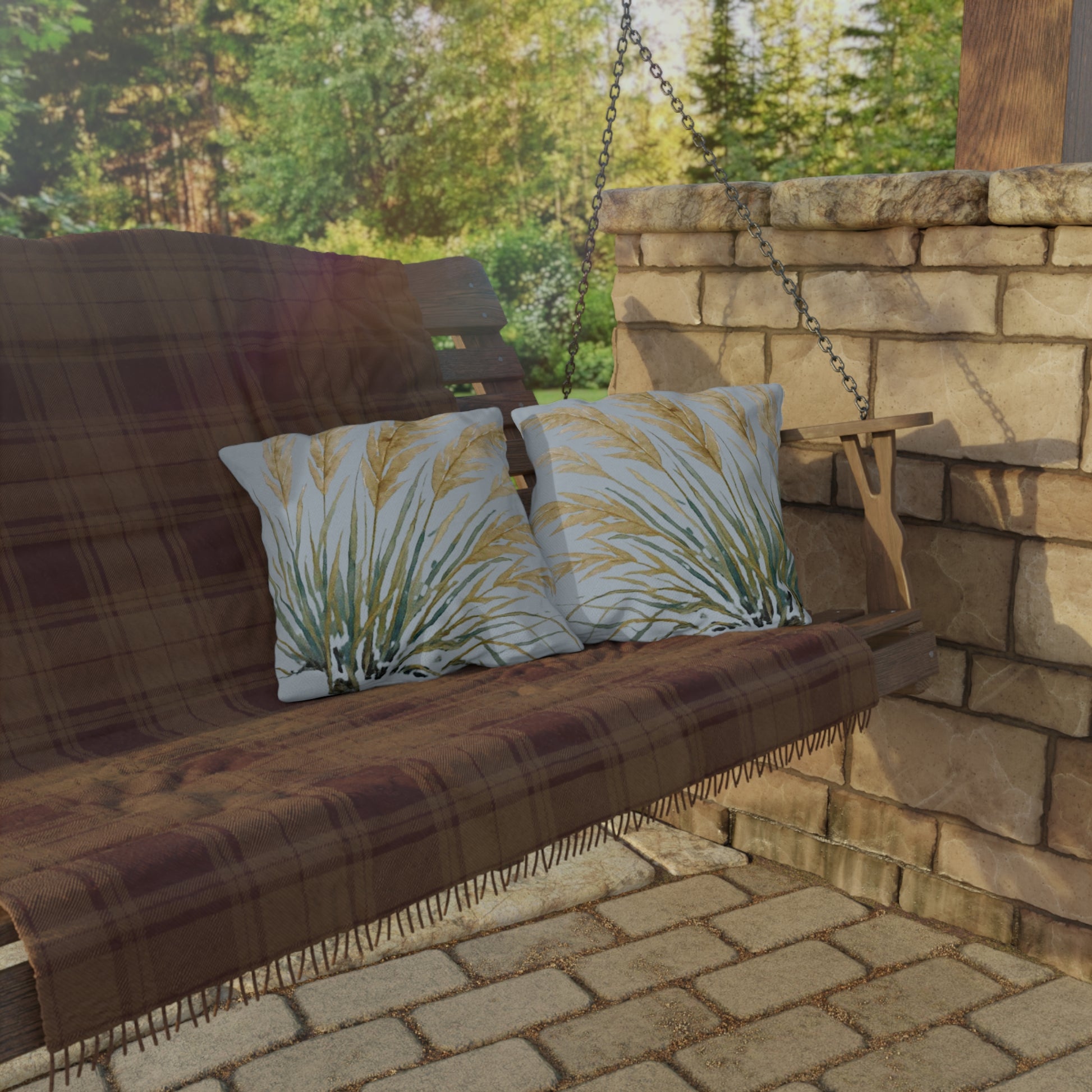 Wooden swing with plaid cover and patterned cushions on a stone patio