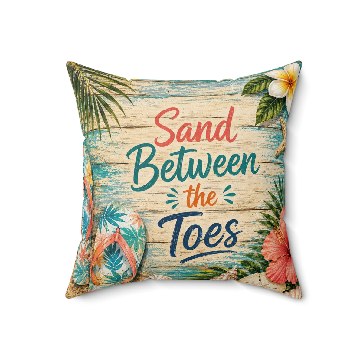 A square decorative throw pillow featuring a tropical beach-themed print with the phrase 'Sand Between the Toes' in coral, teal, and navy lettering. The design includes palm leaves, a white plumeria flower, hibiscus flowers, and flip-flops on a weathered wood background, set against a plain white studio backdrop.